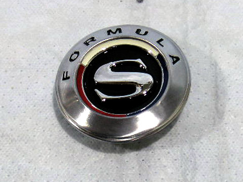 Formula "S" fender emblem.  Tabs are vertical to each other on the backside.