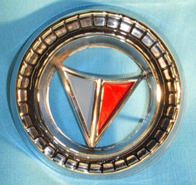 This is a USED 1965 Valiant Signet grill emblem that is in decent condition, however, the mounting studs on the back of the emblem do have some bends but are not broken off. This part has no pitting and the chrome is in very nice condition.