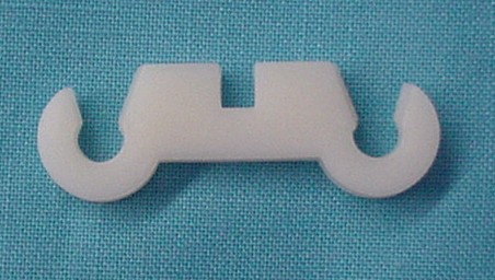 Small-block Spark Plug Wire Retainer. White, like original - holds 2 wires. This retainer snaps onto the welded tabs located on the valve covers. Reproduction.