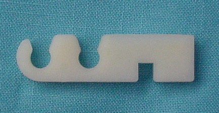 Small-block Spark Plug Wire Retainer. White, like original - holds 2 wires. This retainer snaps onto the welded tabs located on the valve covers. Reproduction.