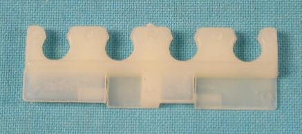 Spark Plug Wire Retainer for 383, 400 & 440 engines. This is the white plastic retainer that snaps onto the brackets mounted at the front corners of the exhaust manifolds and at the thermostat housing. Reproduction. Holds 4 wires.