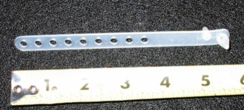 Reproduction white 5" wire strap. Multiple holes-wraps around & plugs back into itself. 9 hole strap