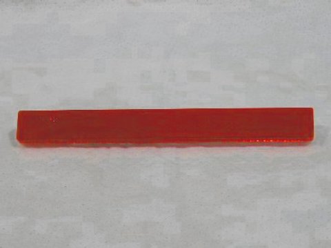 Red (adhesive) quarter panel reflector lens.
IMPORTANT
Factory side marker reflectors were originally produced by several manufacturers.  Some reflectors had a 1/16" plastic backing underneath the lens while others did not.  This reproduction DOES include the plastic backing, so the lens may extend "outward" further than some originals.  This condition IS NOT AN ERROR.
