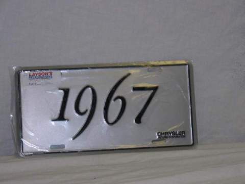 Silver plate with "1967" in black script.