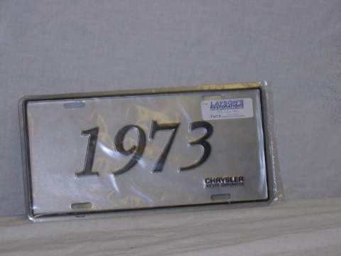 License Plate Silver plate, shows the year (1973) of the car in black script.