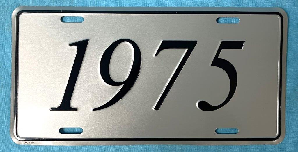 License Plate Silver plate, shows the year (1975) of the car in black script.