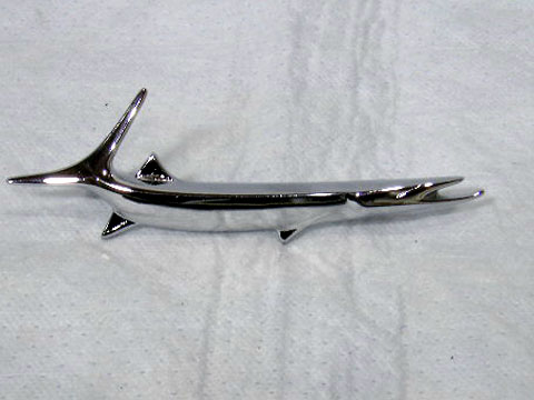 Fender "fish"  passenger side emblem #2785 320 - 2-9/16" between the mounting pegs.