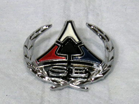 Charger SE roof post nameplate. This is the emblem with the chrome "laurel wreath". Use 2 per car. Note: The original emblems used grained, colored plastic inserts. These inserts are metal and painted.
