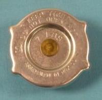 New 7 lb radiator cap - flat top - no pressure relief flap.  Meant for moderate climates where you do not need the poundage for extreme temperatures and so by putting longevity on the upper radiator tank seam from creating a leak.