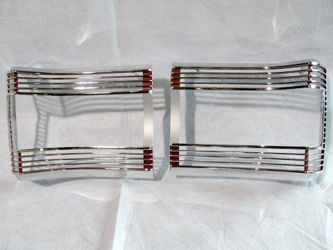 Tail light bezels <b>pair</b>.   These are NOT pot-metal reproductions but a two part allow bezel that won't pit in the future.  Not the same as those low cost China pot-metal ones on the market for half the price - those are pitting out of the box.  These are a high quality  part !!!   <i>Please Note:
The left side bezel was incorrectly labeled on the back as the right side and visa versa for the right side as well</i>.(discount exempt)...