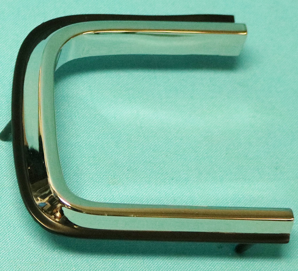 Taillight lens mldg - Drivers side - fits on lens itself.  Not Pot-Metal but better 2 part alloy reproductions - painted black on edge